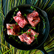 Load image into Gallery viewer, 100% grass-fed and field harvested bison meaty bones in a black skillet with thyme