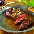 Load image into Gallery viewer, 100% grass-fed and field harvested bison ribeye on a blue plate