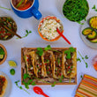 Load image into Gallery viewer, 100% grass fed and field harvested buffalo chorizo street tacos on a white background surrounded by toppings