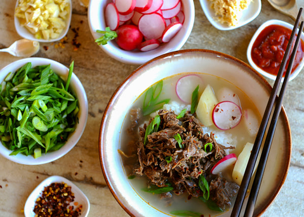Bison Ox-Bone Soup in Bowl with shredded Bison meat and condiments
