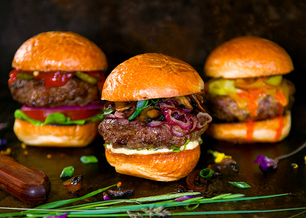 Three Grass-Fed Bison Burgers in Buns with various toppings