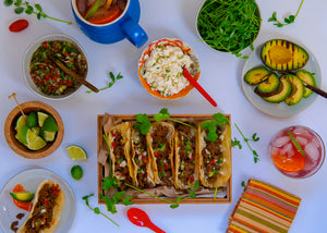 100% grass-fed buffalo tacos surrounded by toppings on a white background