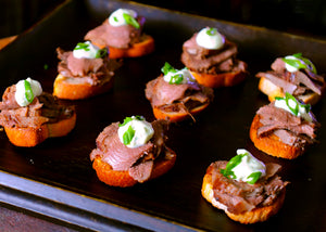 Bison tongue sliced and served on canapes with sour cream
