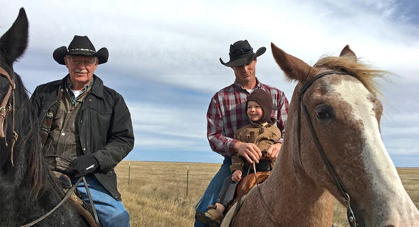 Colton Jones and his grandfather on two horses