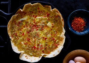 Unbaked quiche in tortilla shell with bison meat