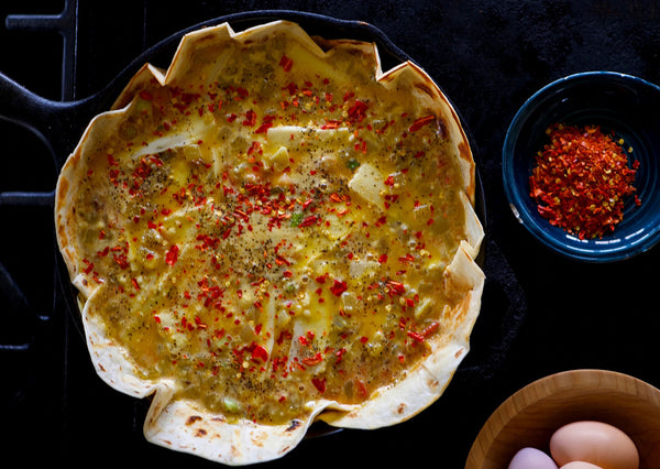 Unbaked quiche in tortilla shell with bison meat