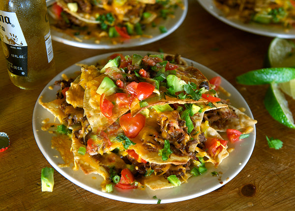 Bison Nachos with tomatoes, onion & avocado on a plate