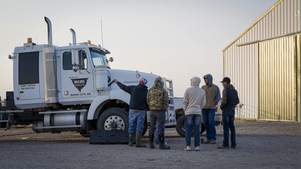 Harvest crew standing next to mobile harvest unit