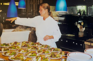 Jill standing in a kitchen around prepared plates of food