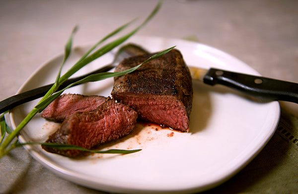 100% grassfed steak on a white plate