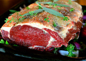 Grass-fed bison prime rib roast uncooked with herbs