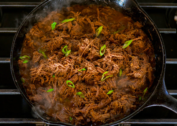 Bison Chuck Roast, braised and pulled in a black skillet