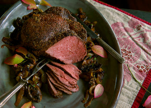 Grass-fed bison Roast sliced on a platter with mushrooms