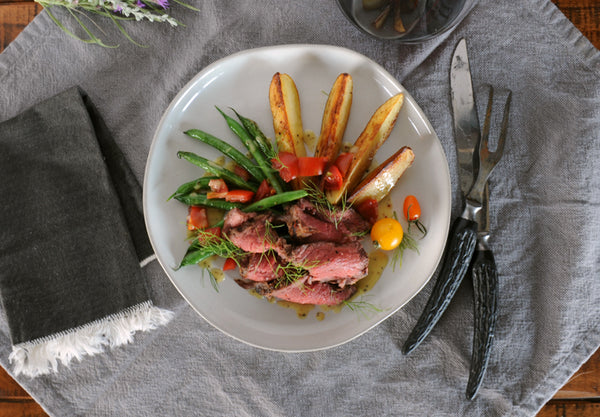 Steak salad in a white bowl