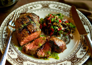 Grass-FEd Bison Steak Sliced with Green Garlic Butter on a plate