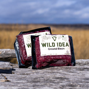 Packages of Wild Idea Ground Bison on a wooden surface with a natural background