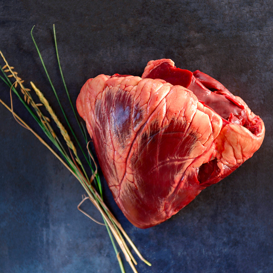 100% grass-fed and field harvested raw bison heart on a black background 