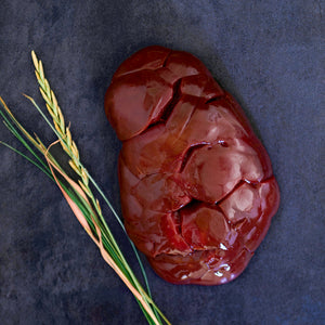 100% grass-fed and field harvested raw buffalo kidney on a black background