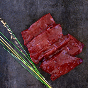 100% grass-fed and field harvested raw bison liver on a black background