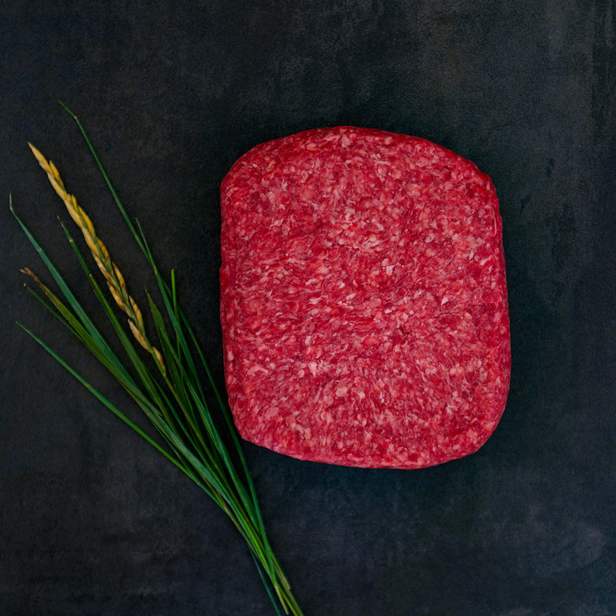 100% grass-fed and field harvested raw ground bison on a black background