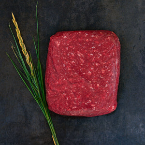 100% grass-fed and field harvested ground bison sirloin on a black background