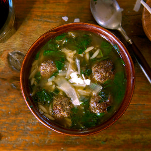 100% grass-fed and field harvested bison italian sausage meatballs in italian wedding soup on a wooden background