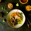 Load image into Gallery viewer, Bison Steak Bulgogi with Rice noodles and sauces on the side
