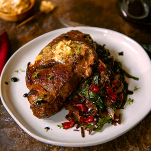 100% grass-fed and field harvested pan seared bison ribeye steak with chard on a white plate