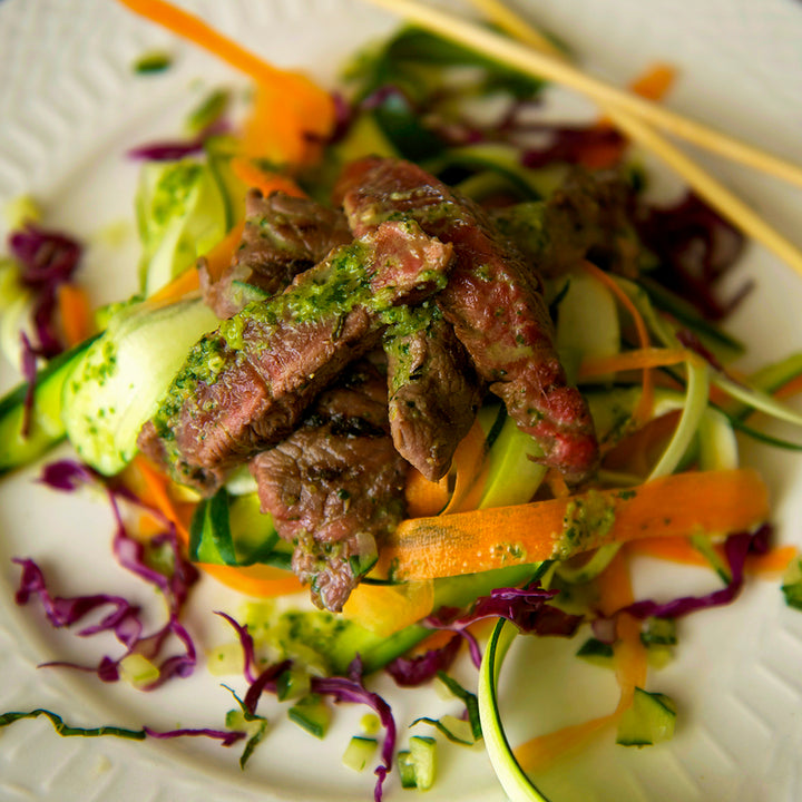 100% grass-fed and field harvested bison steak strips on top of a vietnamese salad