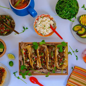 100% grass fed and field harvested buffalo chorizo street tacos on a white background surrounded by toppings