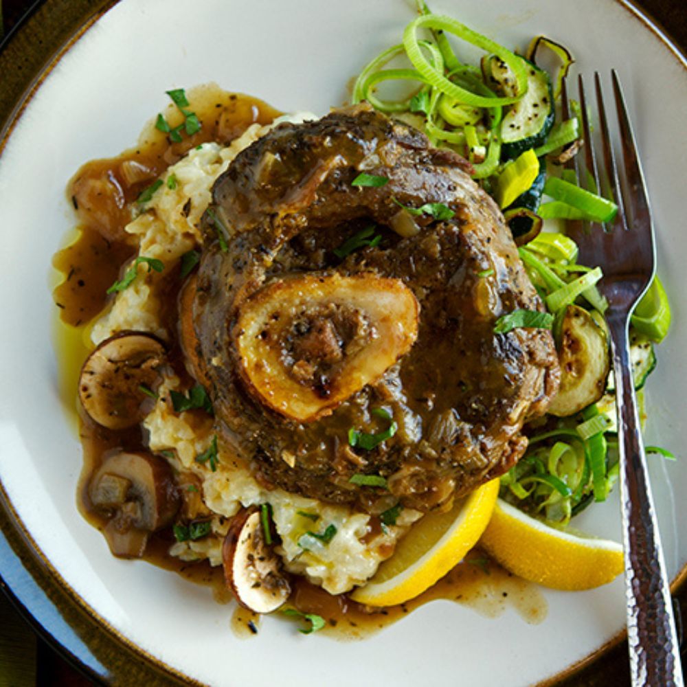overhead shot of buffalo osso bucco atop a bed of risotto and greens